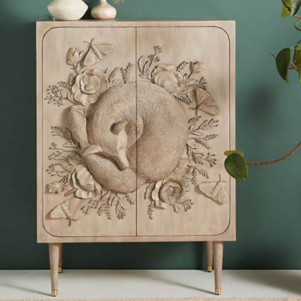 A wooden cabinet adorned with detailed floral carvings and a calming fox motif