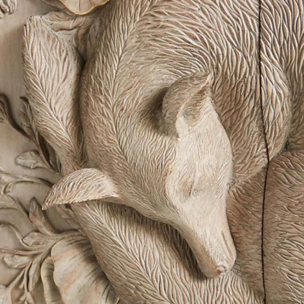 A wooden cabinet adorned with detailed floral carvings and a calming fox motif