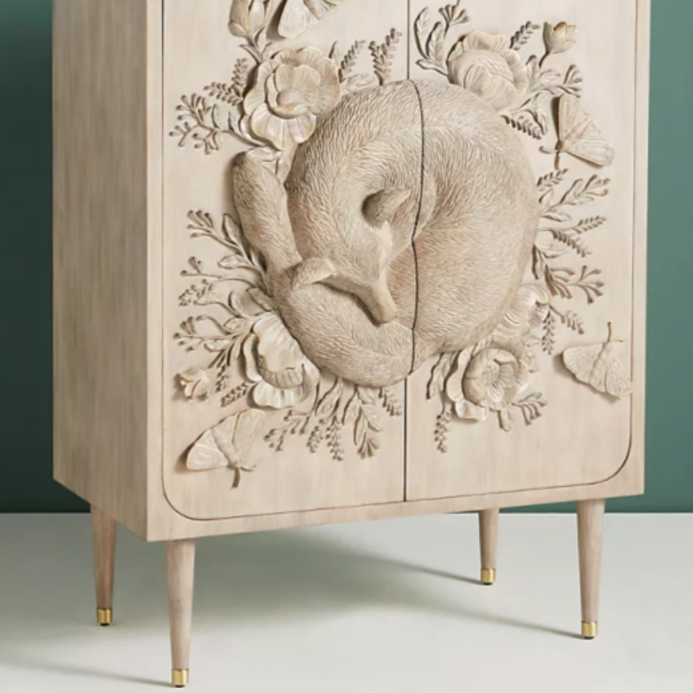 A wooden cabinet adorned with detailed floral carvings and a calming fox motif