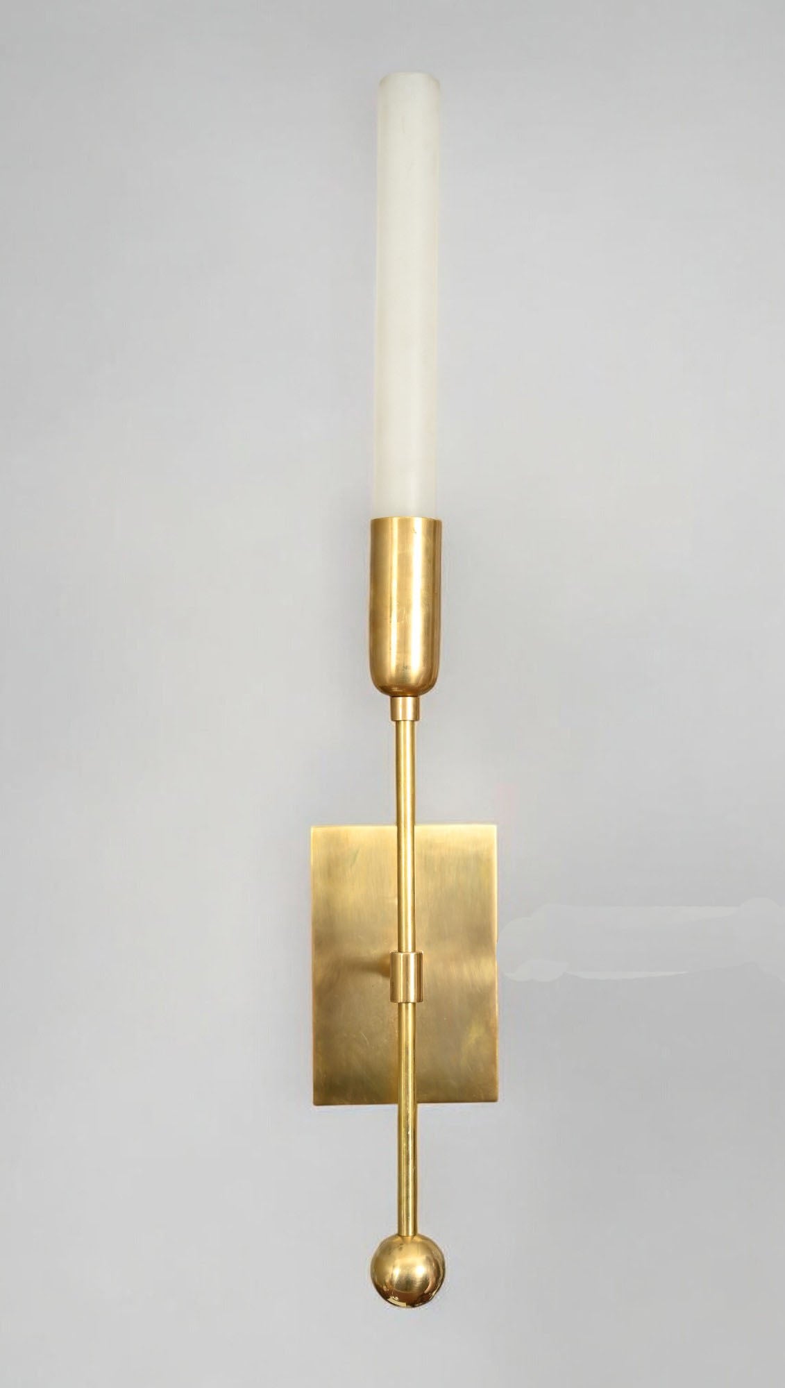 Illuminate your space with the TASSEL 1 Sconce—glass tube with raw brass accents