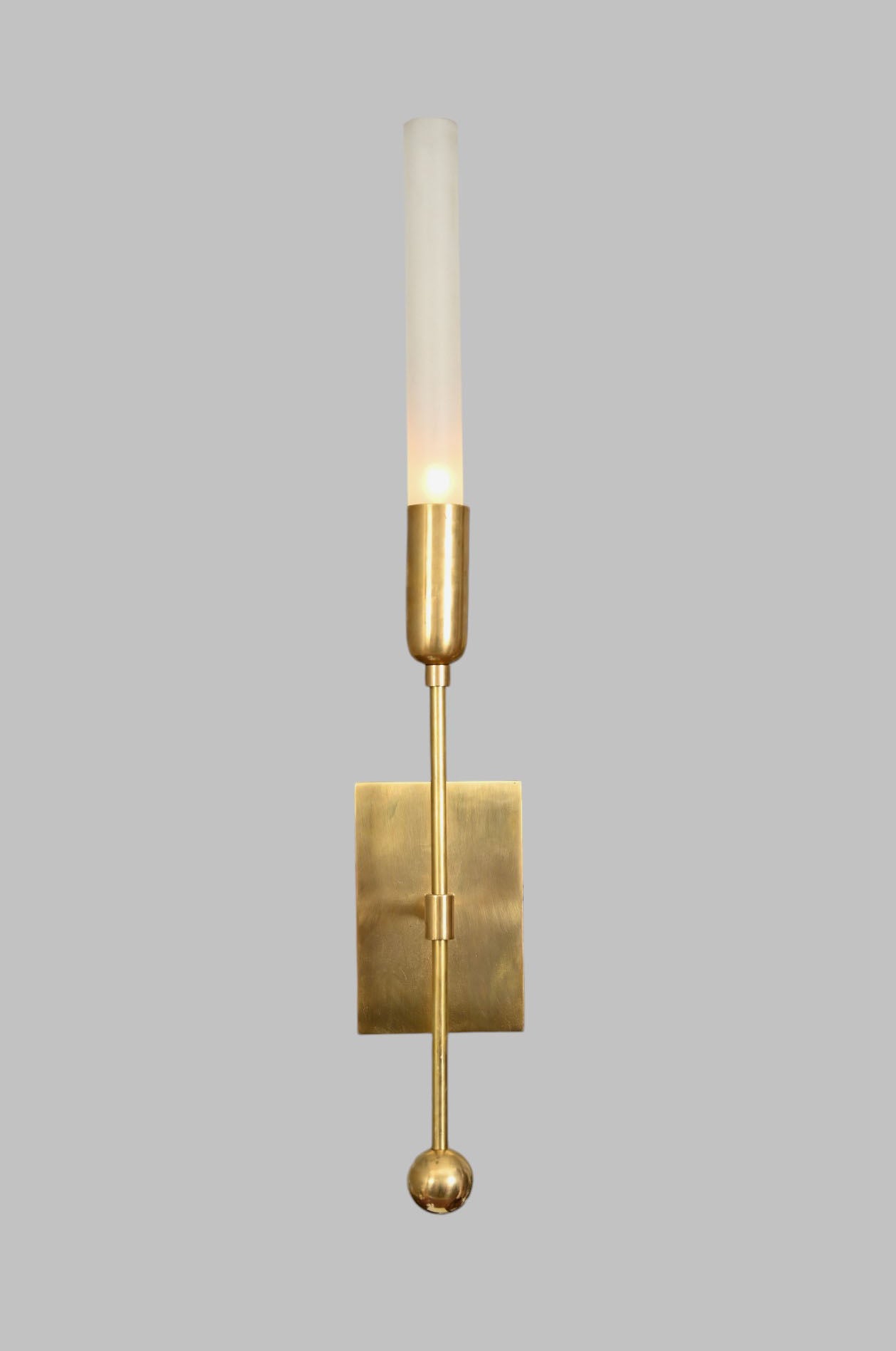 Illuminate your space with the TASSEL 1 Sconce—glass tube with raw brass accents