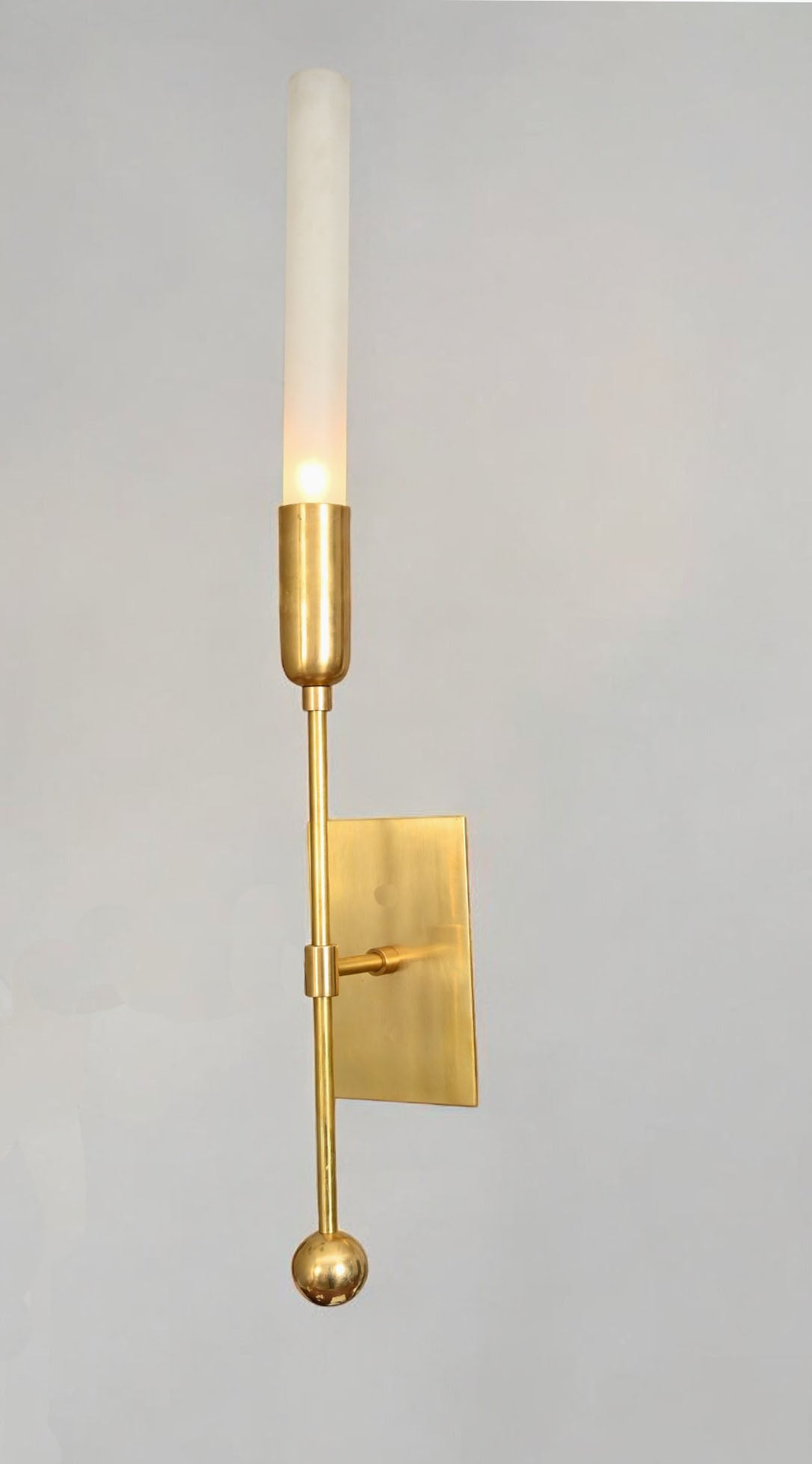 Illuminate your space with the TASSEL 1 Sconce—glass tube with raw brass accents