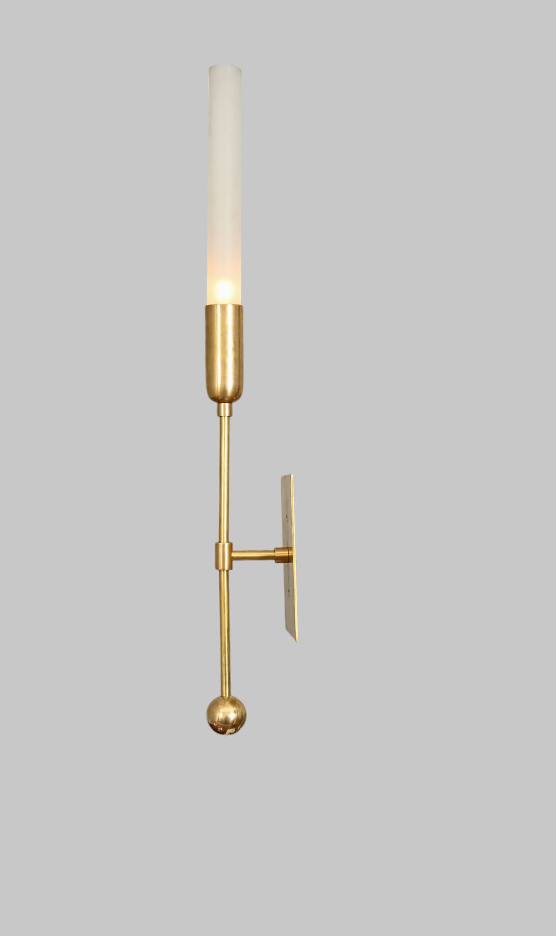 Illuminate your space with the TASSEL 1 Sconce—glass tube with raw brass accents