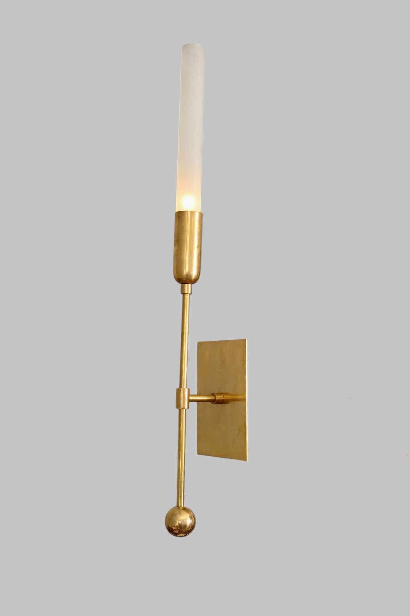 Illuminate your space with the TASSEL 1 Sconce—glass tube with raw brass accents