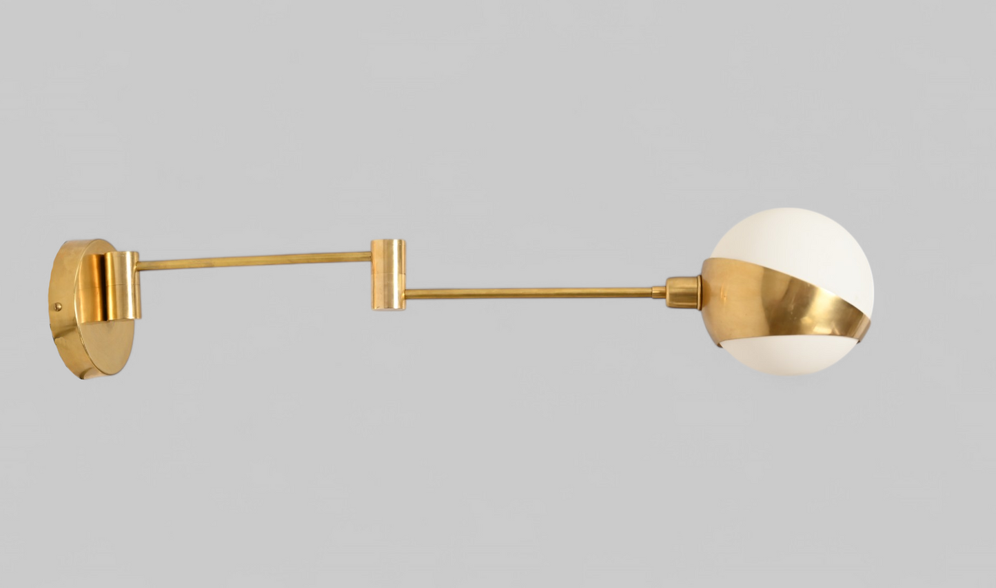 Add elegance with our 1-Light Glass Globe Mid-Century Wall Sconce in Raw Brass