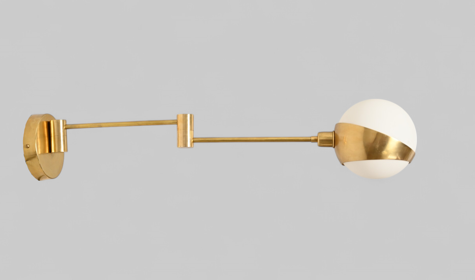 Add elegance with our 1-Light Glass Globe Mid-Century Wall Sconce in Raw Brass