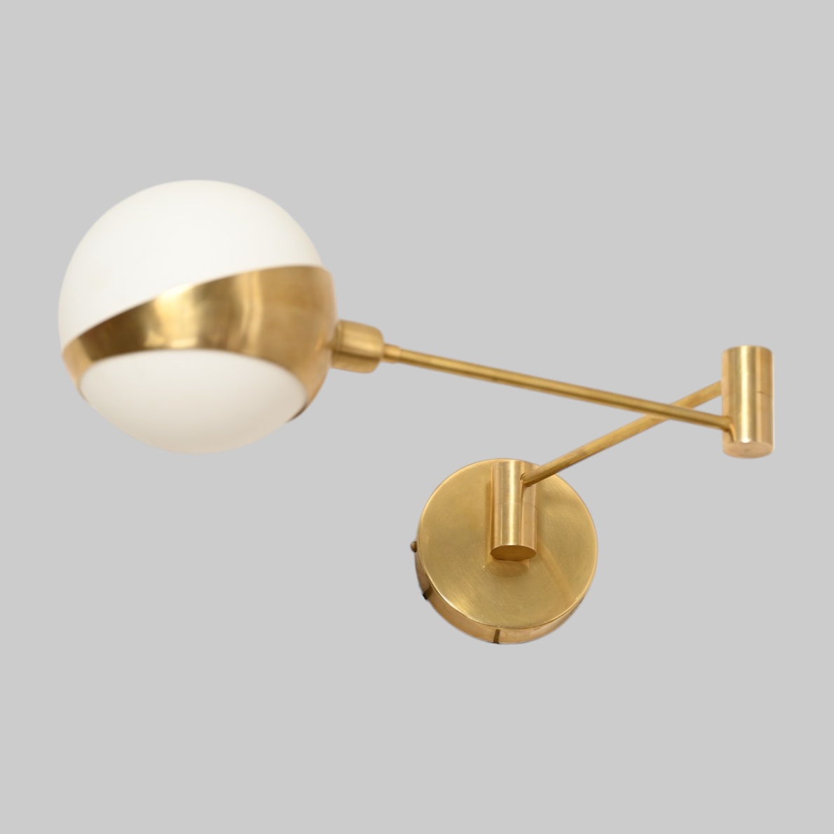 Add elegance with our 1-Light Glass Globe Mid-Century Wall Sconce in Raw Brass