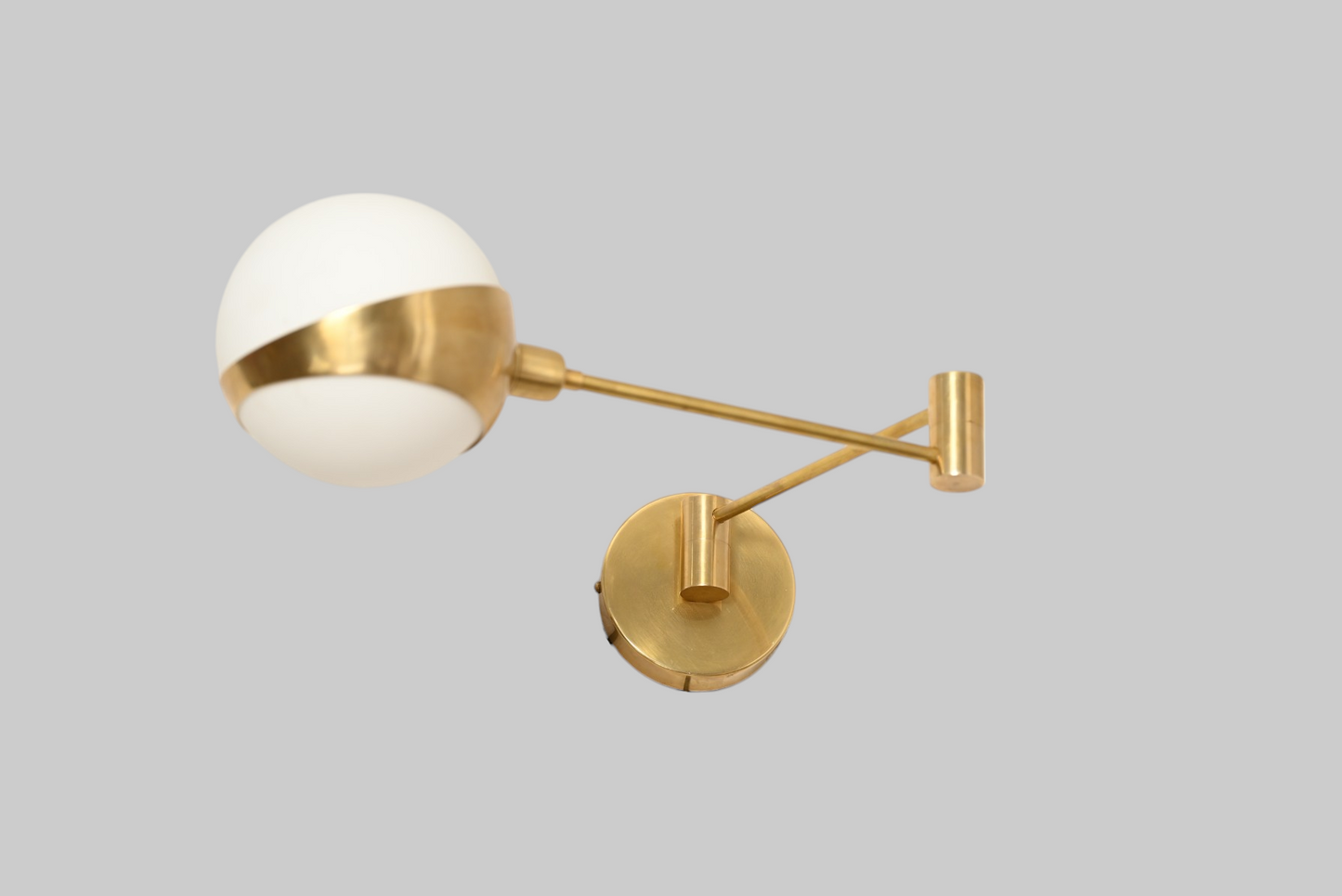 Add elegance with our 1-Light Glass Globe Mid-Century Wall Sconce in Raw Brass