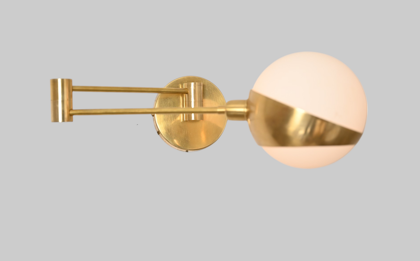 Add elegance with our 1-Light Glass Globe Mid-Century Wall Sconce in Raw Brass