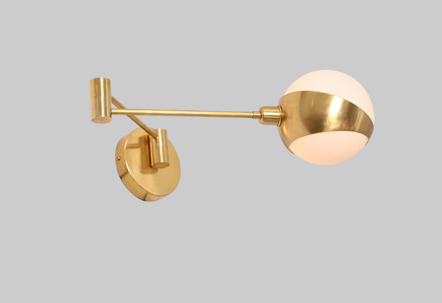 Add elegance with our 1-Light Glass Globe Mid-Century Wall Sconce in Raw Brass