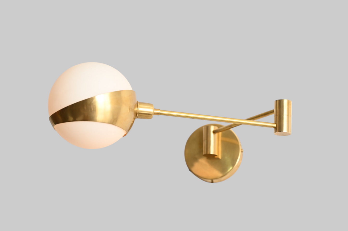 Add elegance with our 1-Light Glass Globe Mid-Century Wall Sconce in Raw Brass