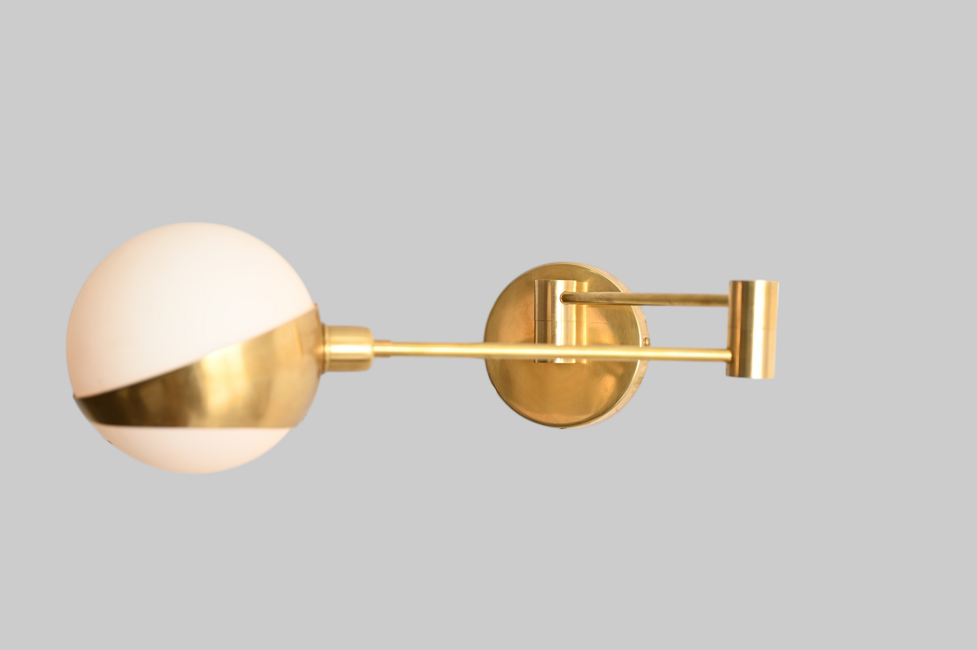 Add elegance with our 1-Light Glass Globe Mid-Century Wall Sconce in Raw Brass