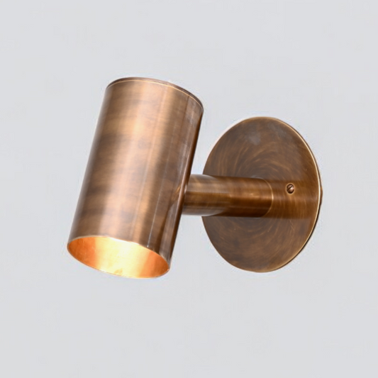 The 1-Light Mid-Century Wall Sconce in Raw Brass blends modern and vintage charm