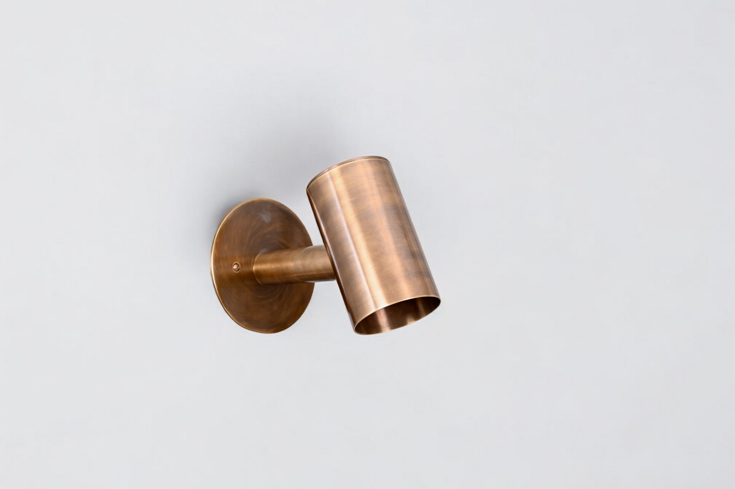 The 1-Light Mid-Century Wall Sconce in Raw Brass blends modern and vintage charm