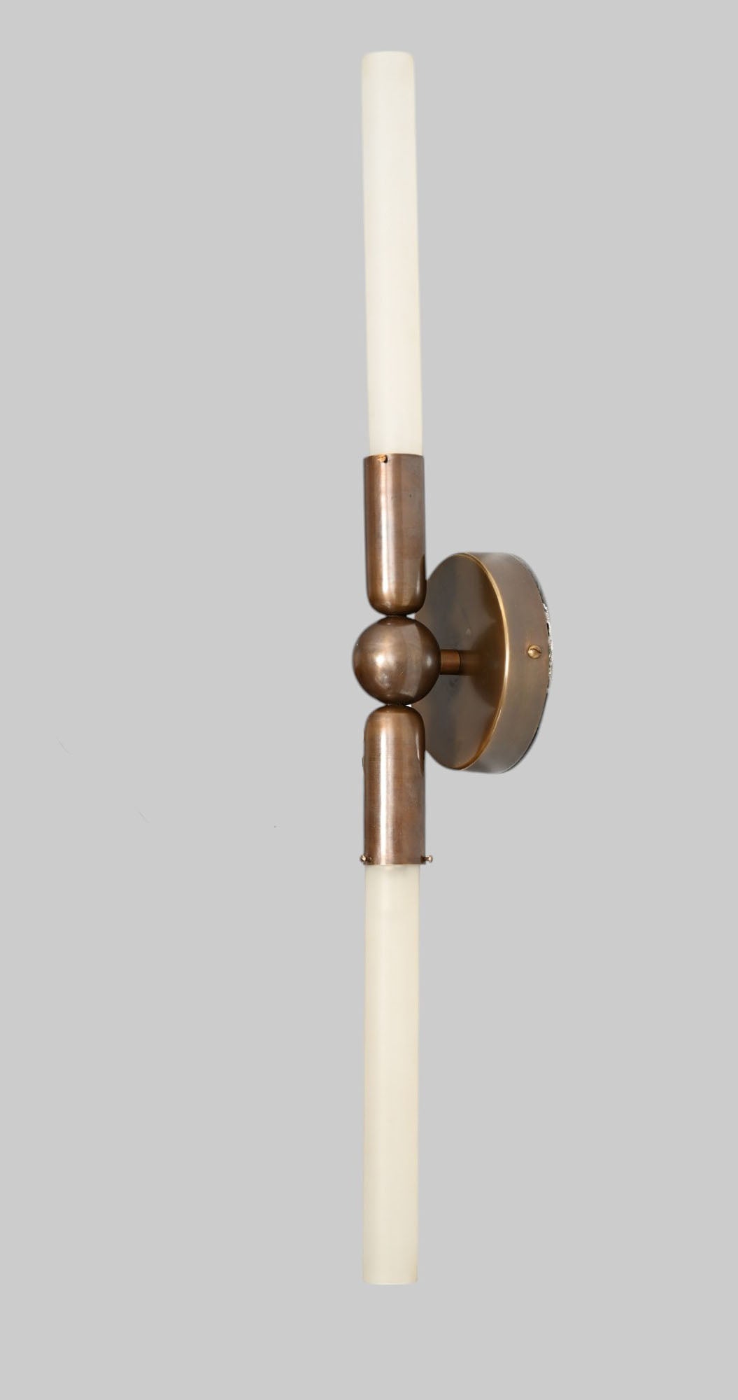 Glass Tube Wall Sconce in Raw Brass blends modern style with industrial charm