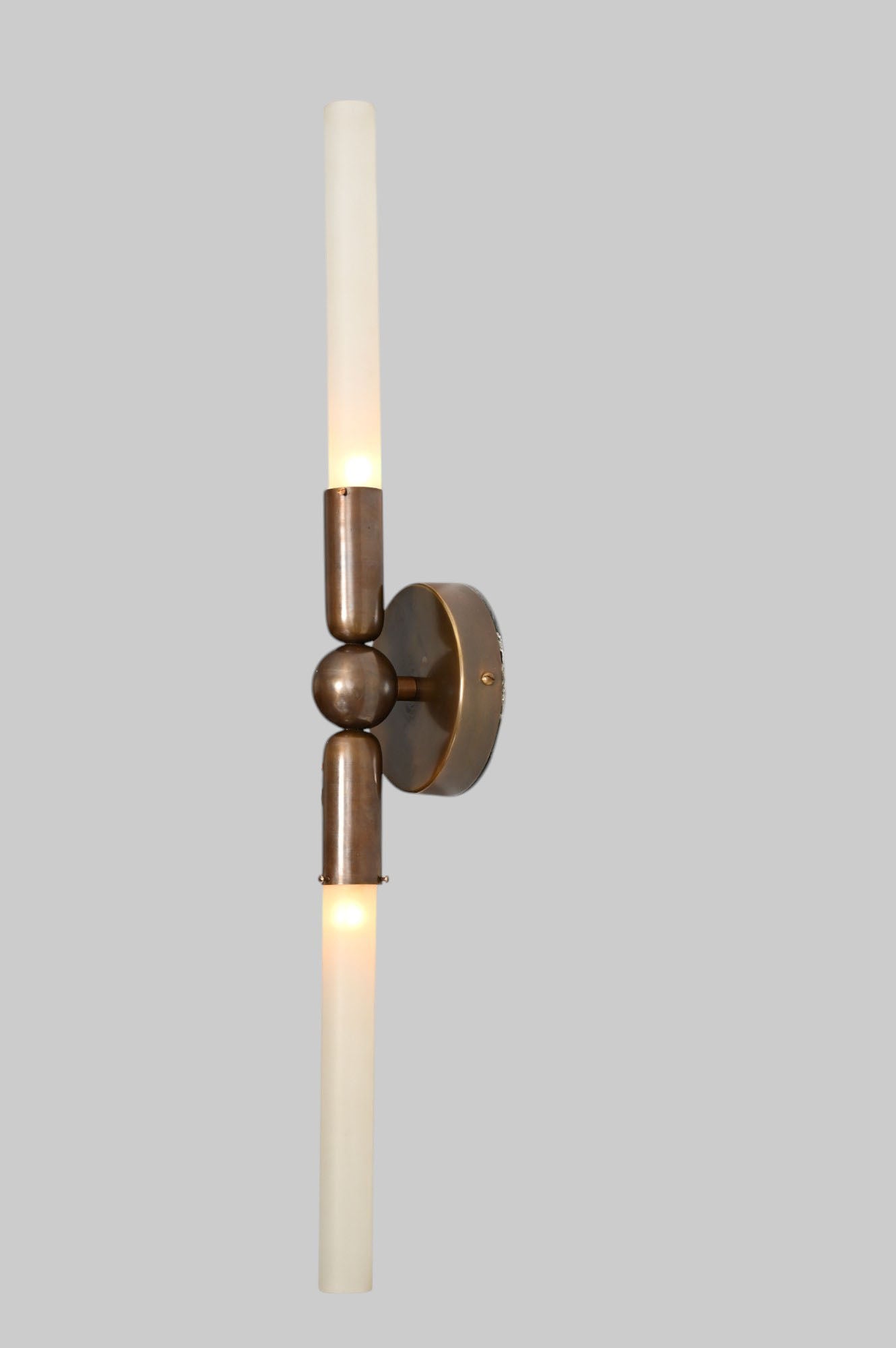 Glass Tube Wall Sconce in Raw Brass blends modern style with industrial charm