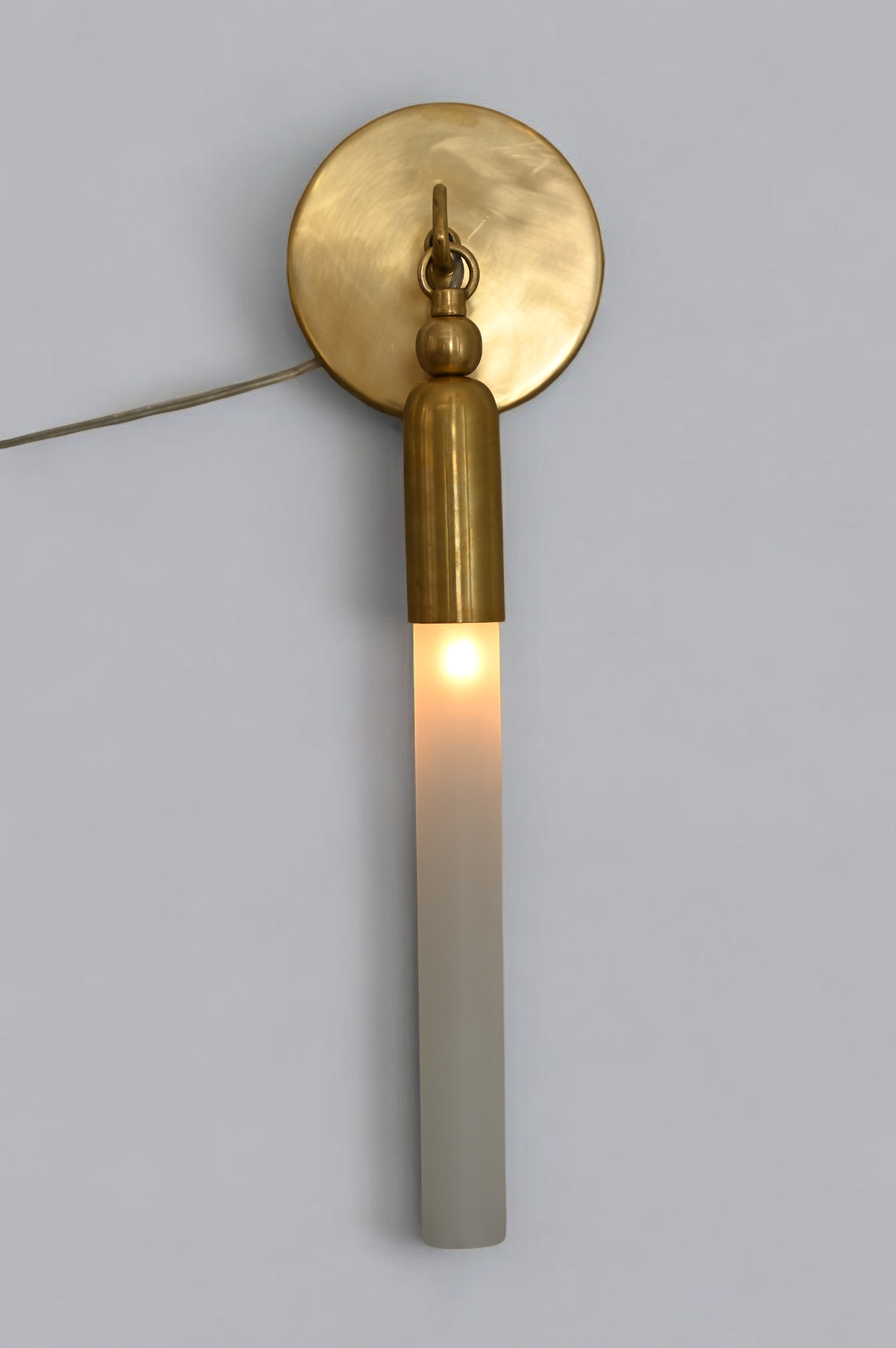 Illuminate your space with the TASSEL 1 Sconce—sleek glass tube and brass accents