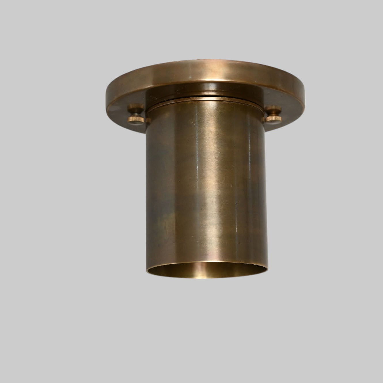 Sleek antique brass downlight adds warm, modern elegance to any space