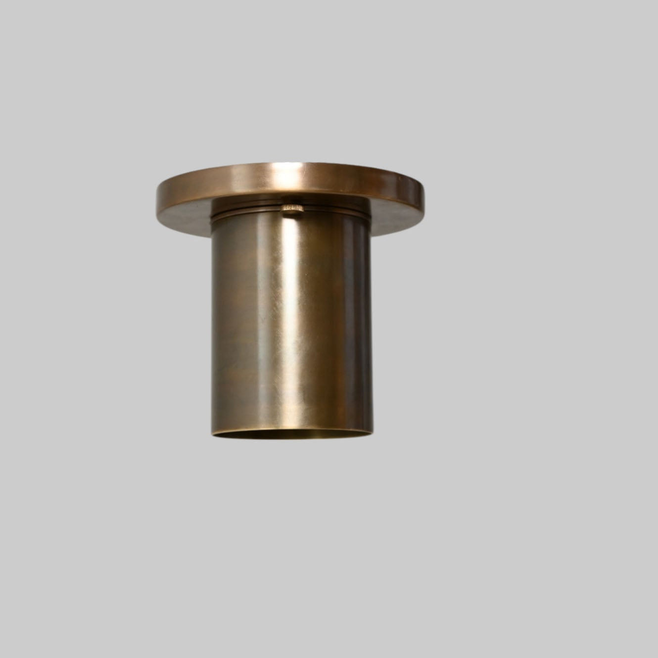 Sleek antique brass downlight adds warm, modern elegance to any space