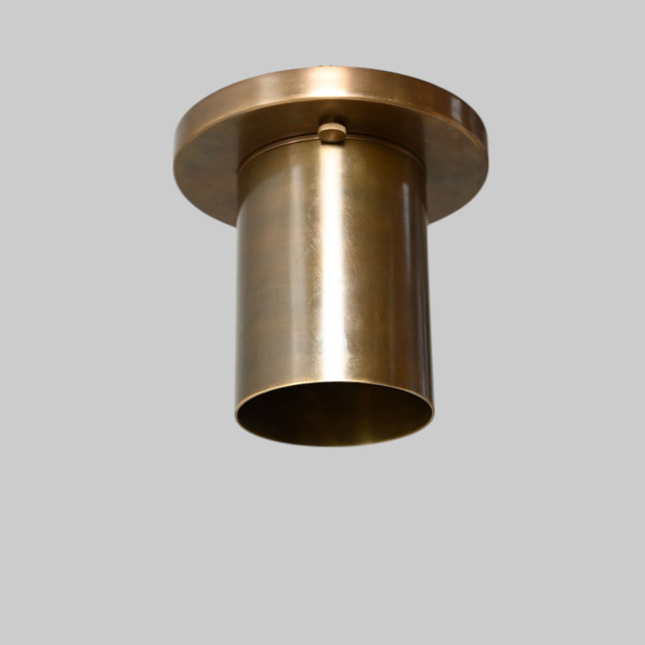 Sleek antique brass downlight adds warm, modern elegance to any space