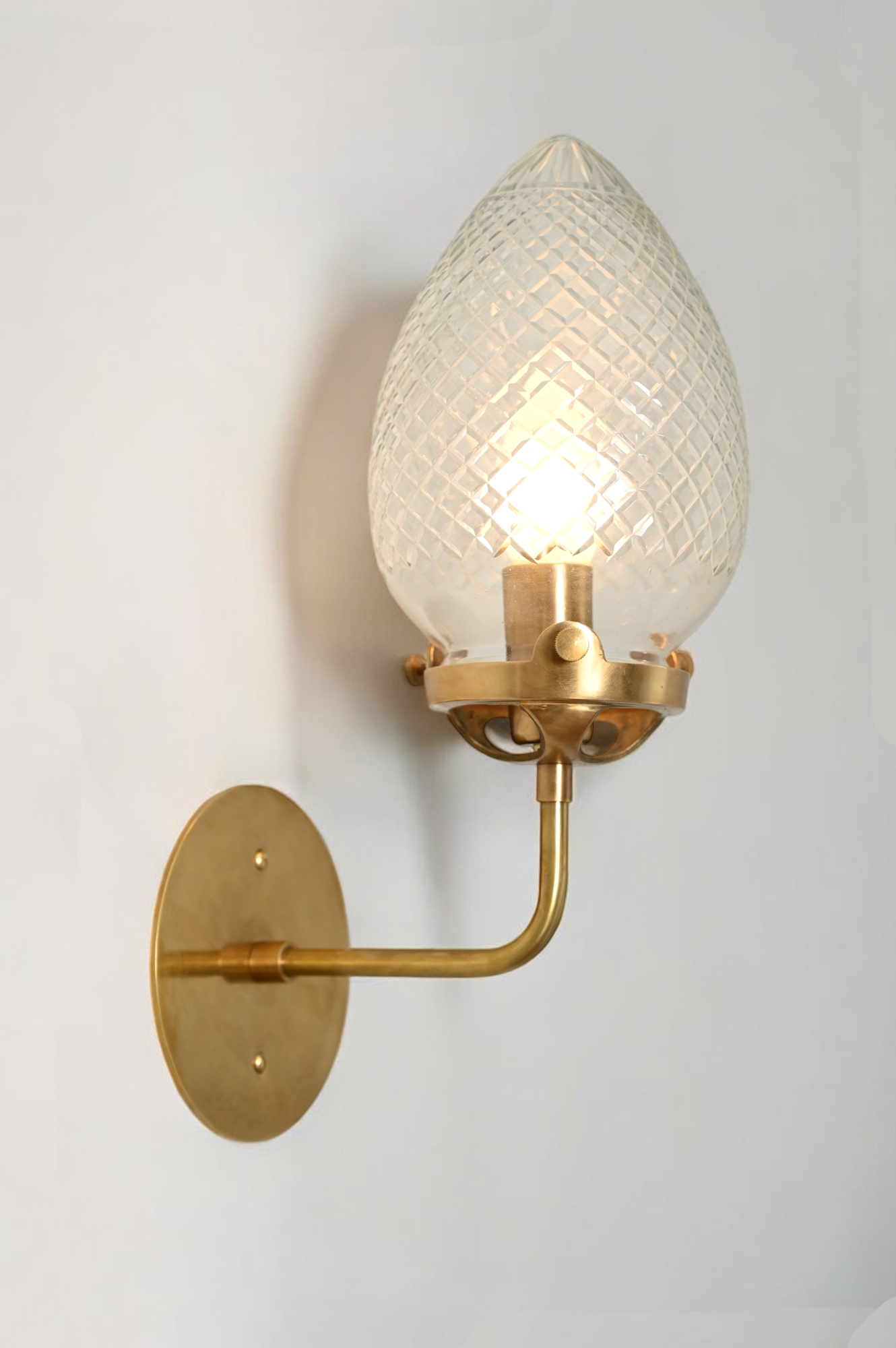 Brighten your space with the Conical Globes Wall Sconce, featuring raw brass charm