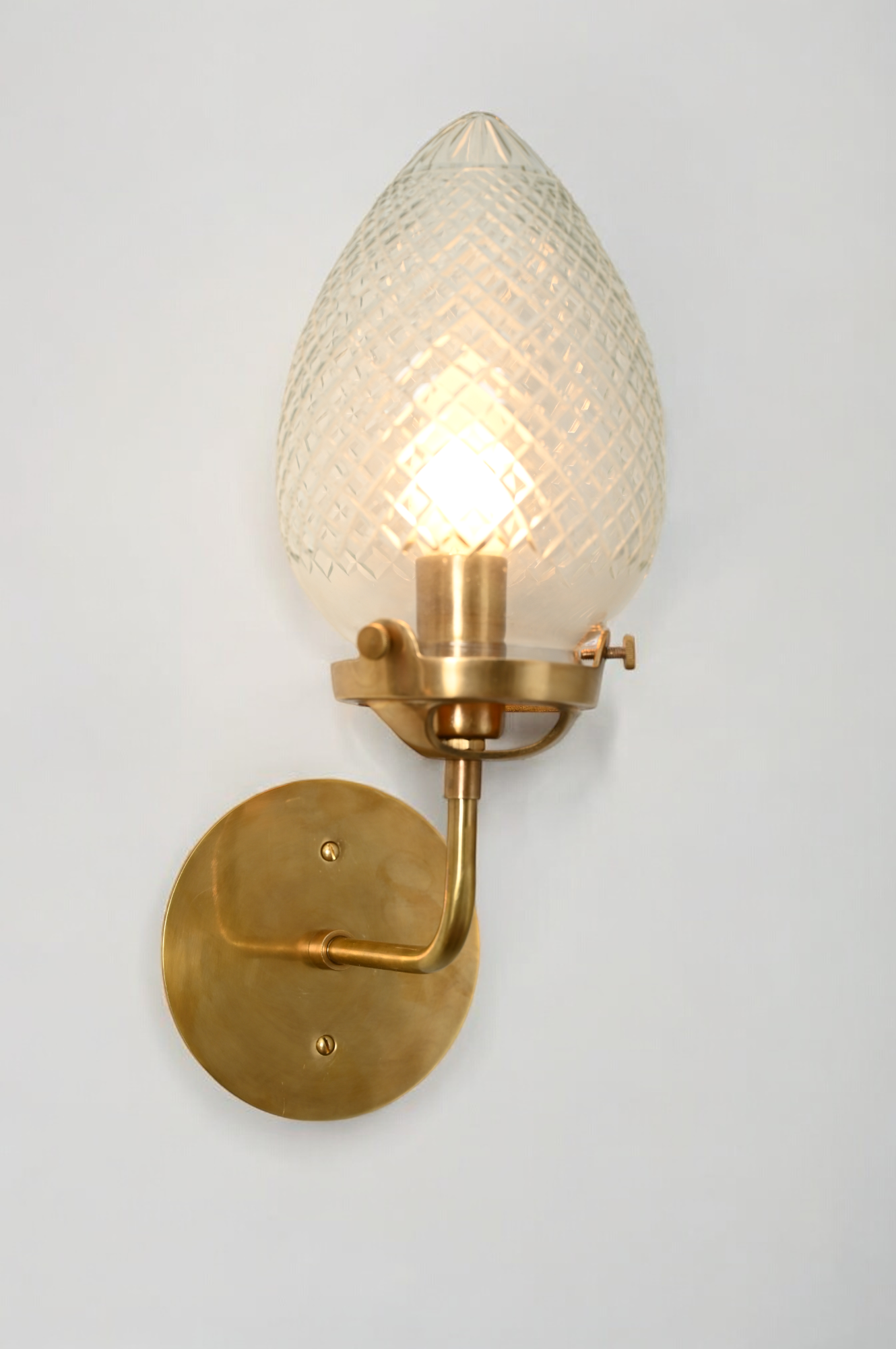 Brighten your space with the Conical Globes Wall Sconce, featuring raw brass charm