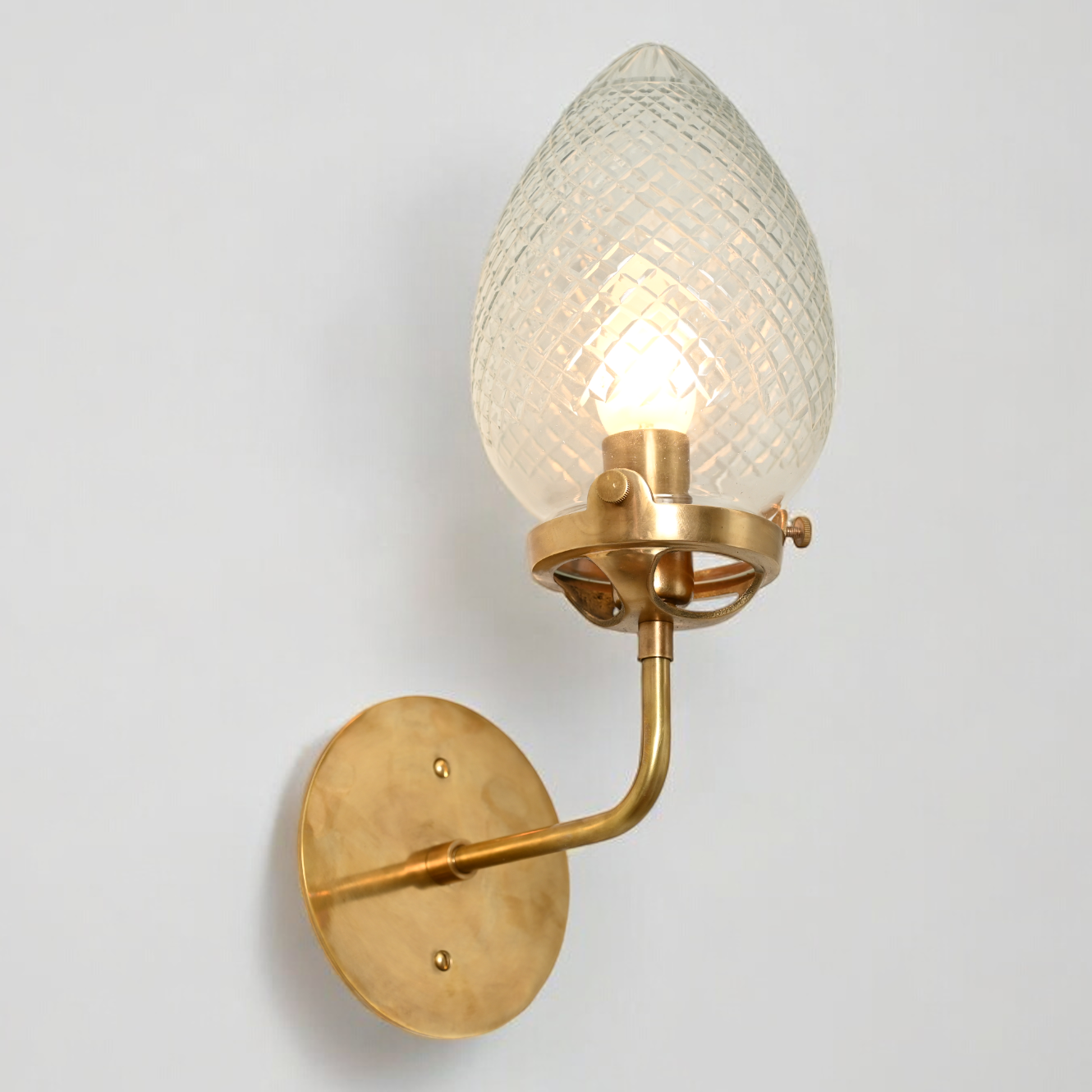 Brighten your space with the Conical Globes Wall Sconce, featuring raw brass charm