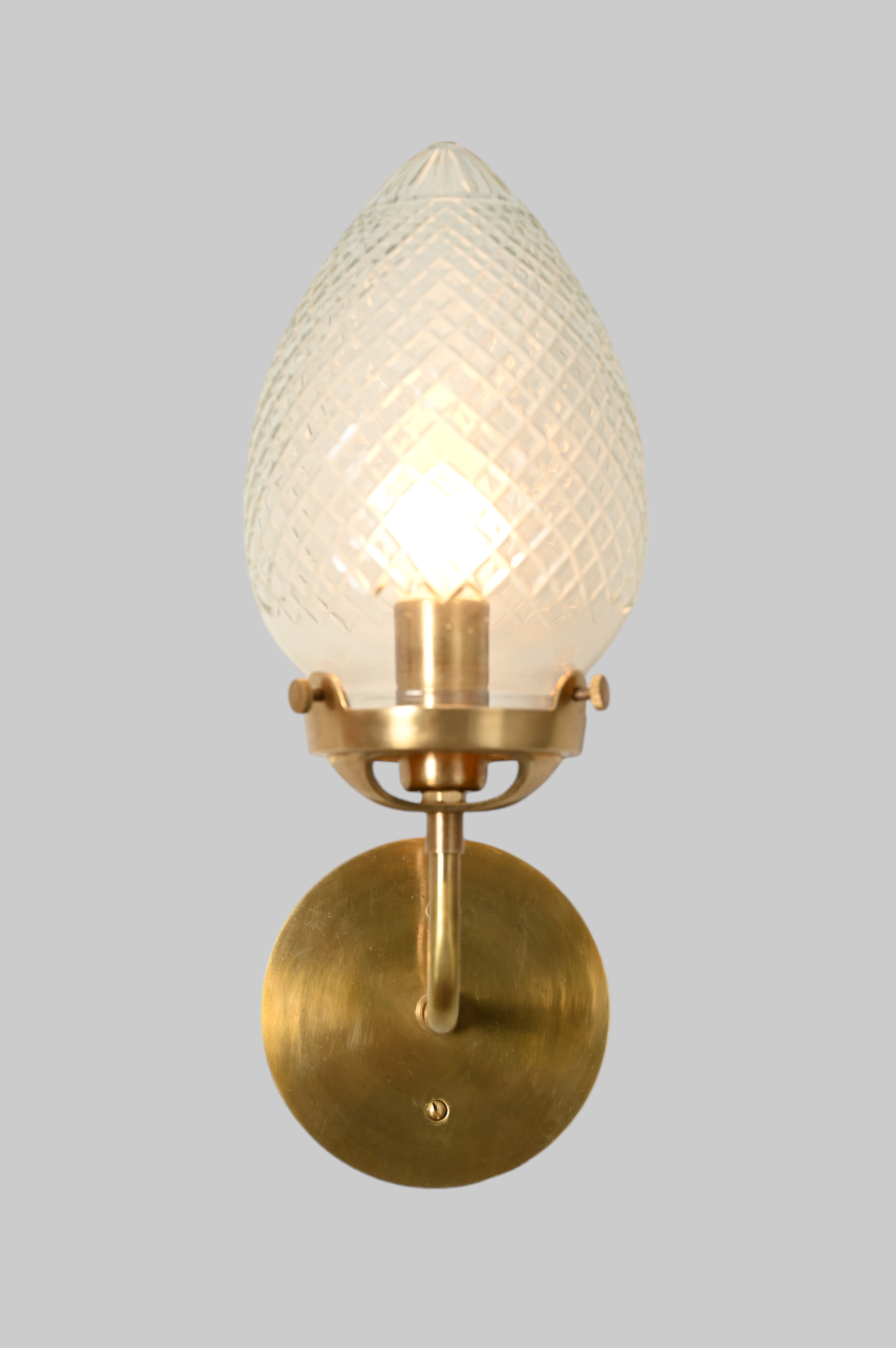 Brighten your space with the Conical Globes Wall Sconce, featuring raw brass charm