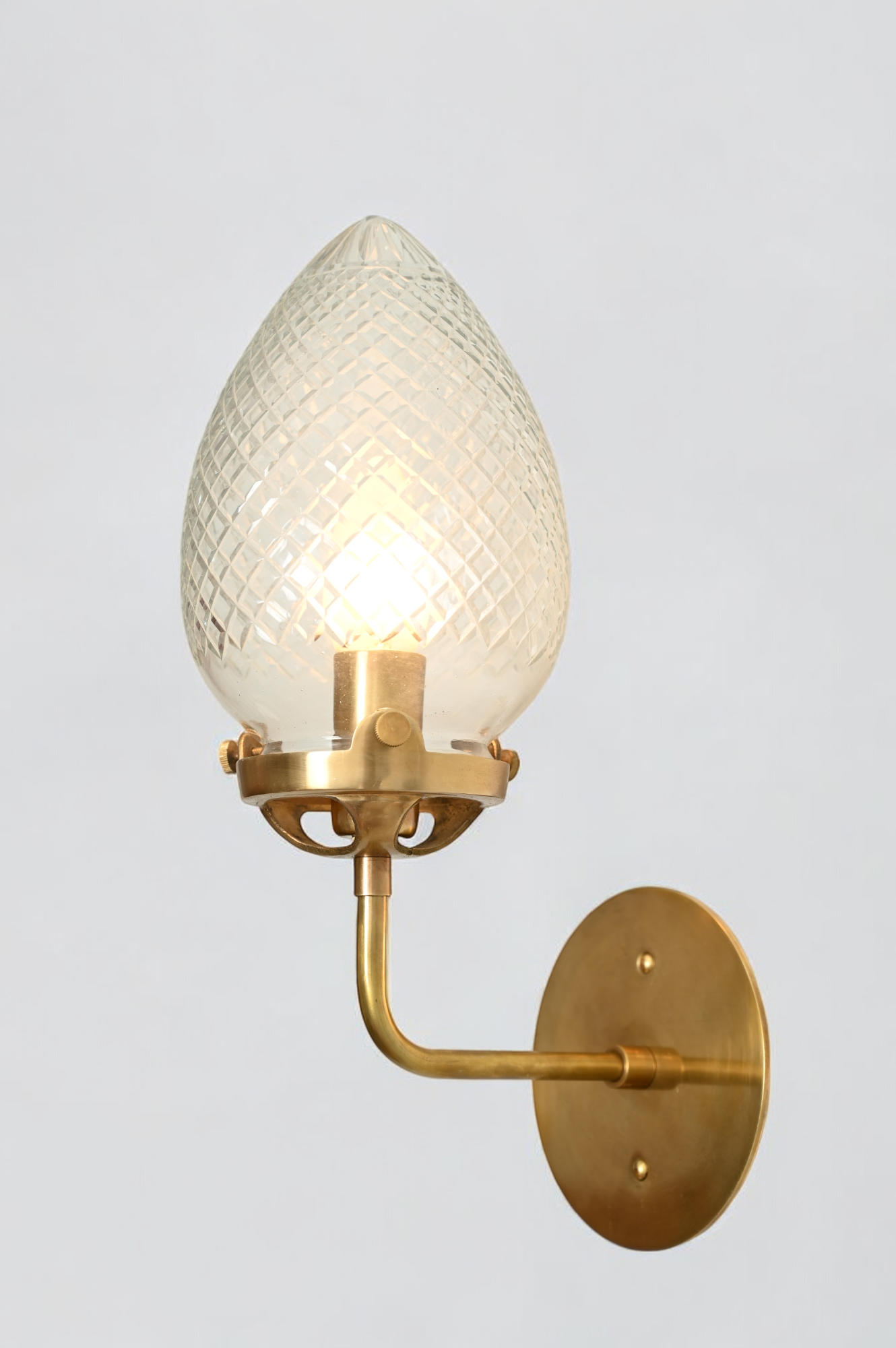 Brighten your space with the Conical Globes Wall Sconce, featuring raw brass charm