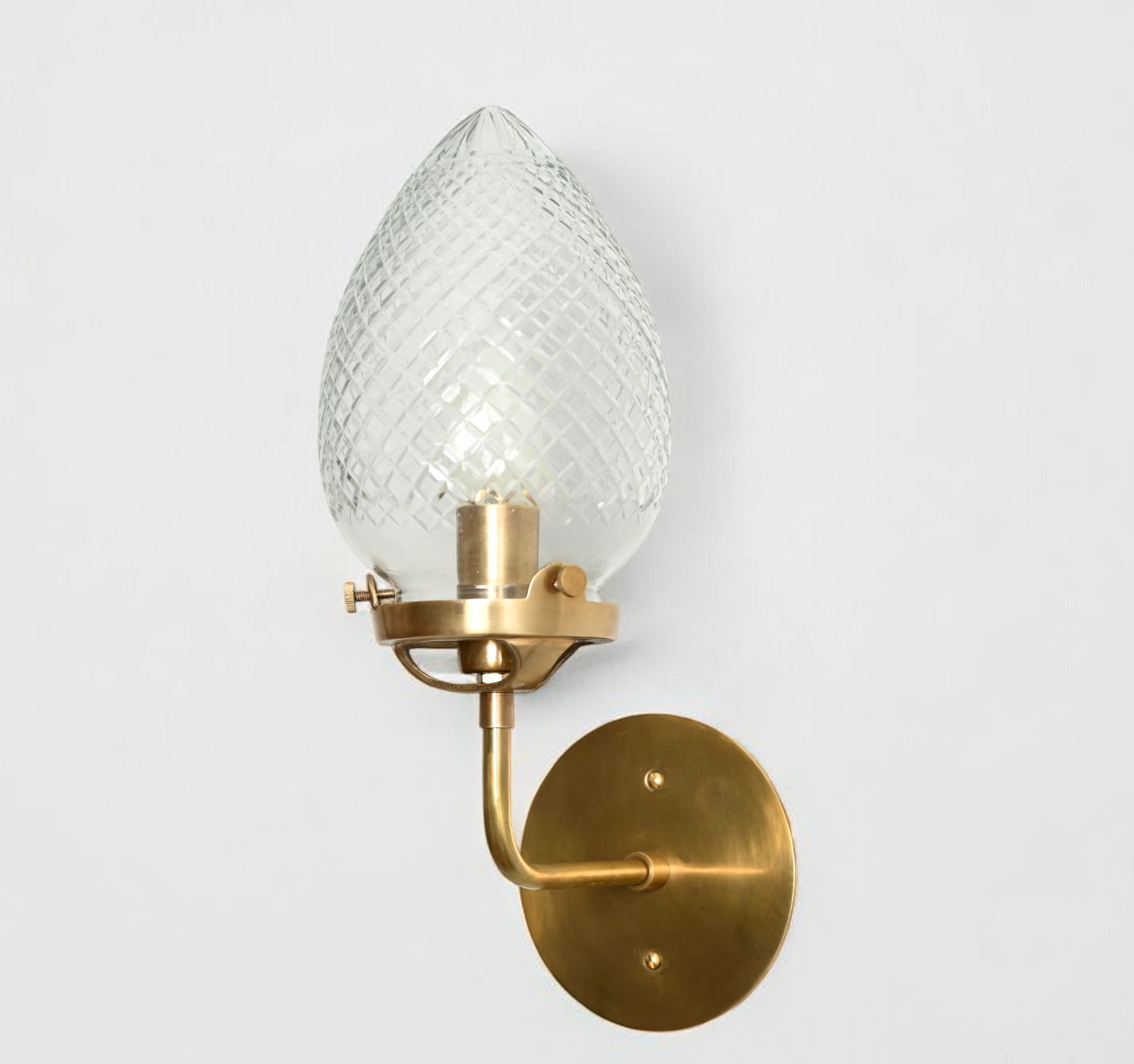 Brighten your space with the Conical Globes Wall Sconce, featuring raw brass charm