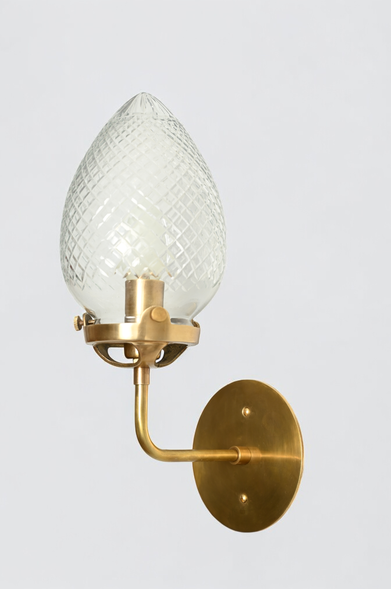 Brighten your space with the Conical Globes Wall Sconce, featuring raw brass charm