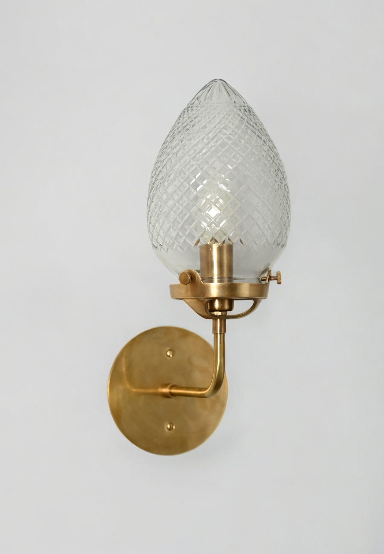 Brighten your space with the Conical Globes Wall Sconce, featuring raw brass charm