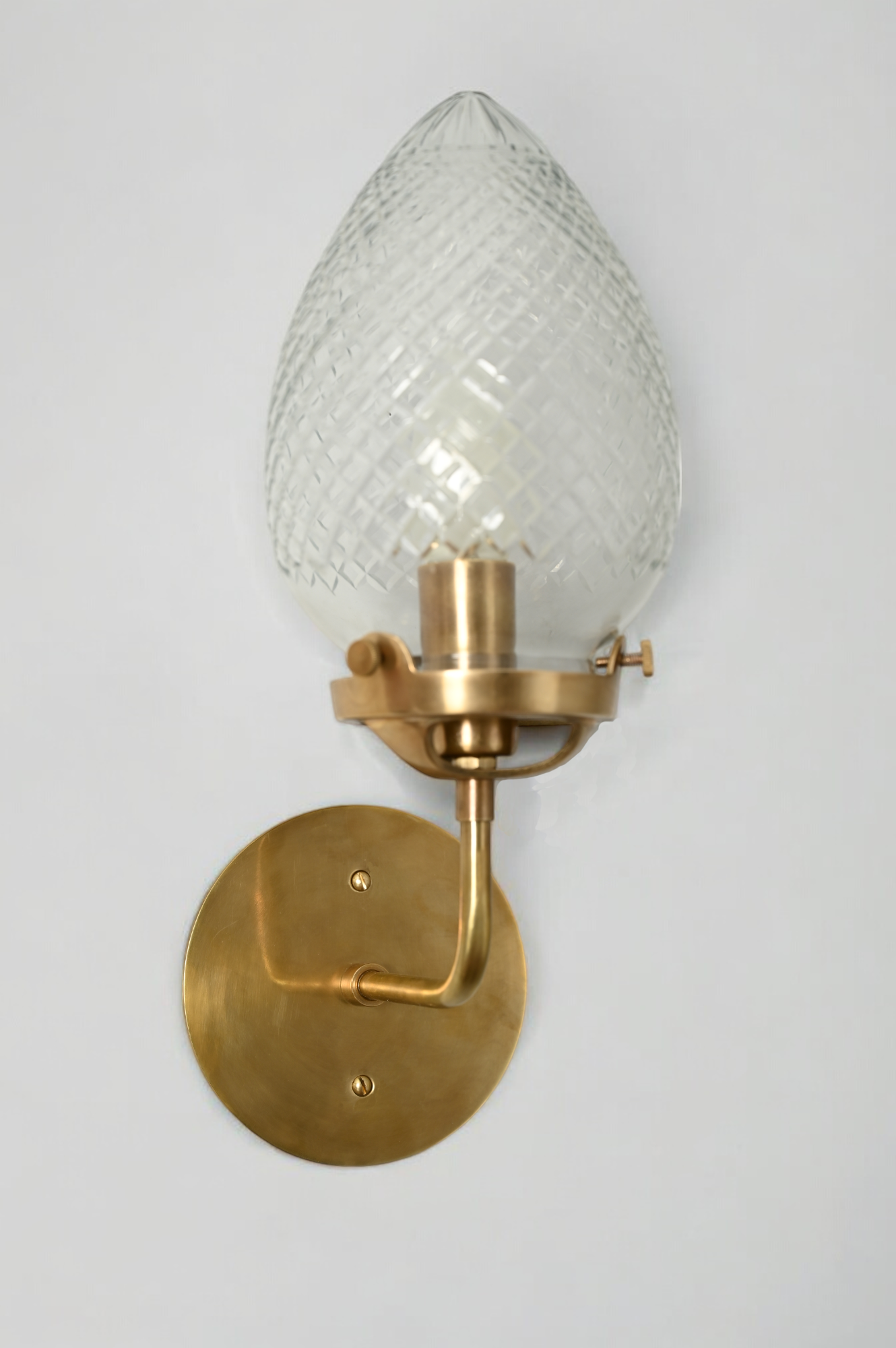 Brighten your space with the Conical Globes Wall Sconce, featuring raw brass charm