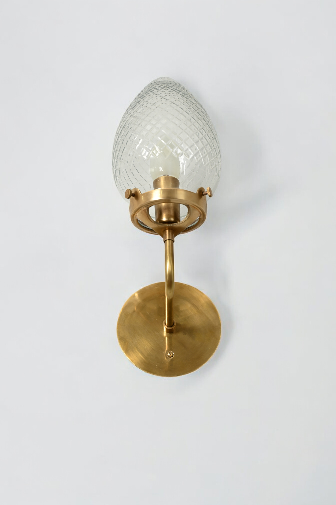 Brighten your space with the Conical Globes Wall Sconce, featuring raw brass charm